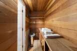 Experience ultimate relaxation in this beautifully crafted wooden sauna, featuring natural wood paneling on the walls and ceiling.
