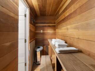 Experience ultimate relaxation in this beautifully crafted wooden sauna, featuring natural wood paneling on the walls and ceiling.