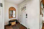 Step into this welcoming entryway featuring a stylish arched mirror and a convenient bench with storage.