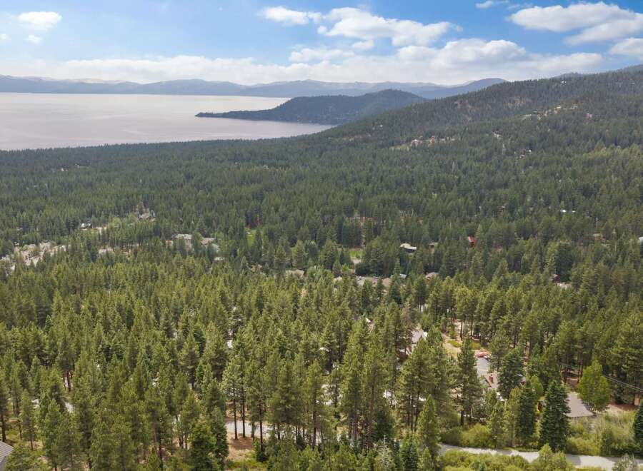 Discover your dream home nestled amidst a lush pine forest with stunning lake views.
