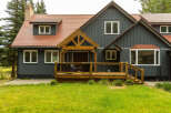 Discover this charming home featuring a rustic wooden porch and a welcoming deck, perfect for outdoor relaxation.