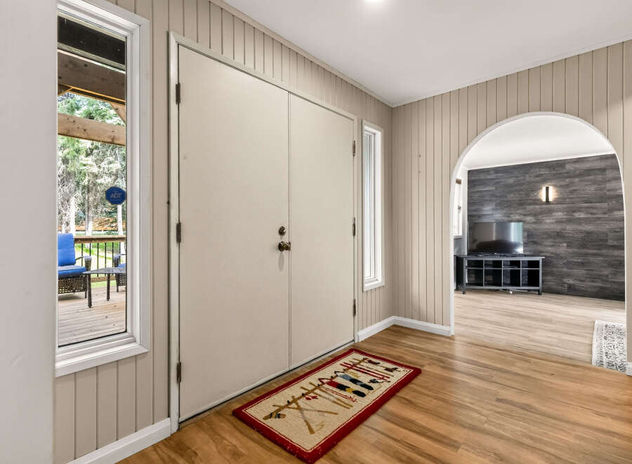 Step into this charming entryway featuring a large double door and a welcoming rug.