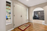 Step into this charming entryway featuring a large double door and a welcoming rug.