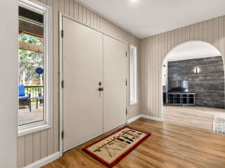 Step into this charming entryway featuring a large double door and a welcoming rug.