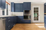 Experience modern elegance in this stunning kitchen, featuring deep navy blue cabinetry that provides a sophisticated contrast to the crisp white subway tile backsplash.