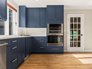 Experience modern elegance in this stunning kitchen, featuring deep navy blue cabinetry that provides a sophisticated contrast to the crisp white subway tile backsplash.