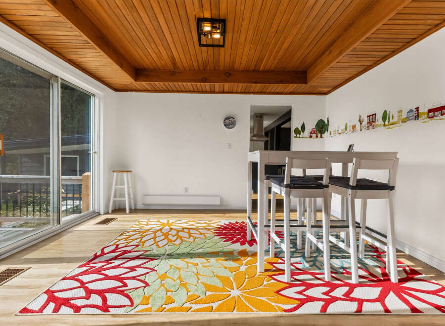 Bright and airy dining area featuring a modern white bar table with four stools, perfect for casual meals or entertaining.