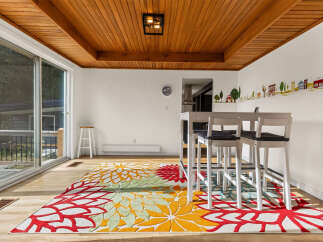 Bright and airy dining area featuring a modern white bar table with four stools, perfect for casual meals or entertaining.