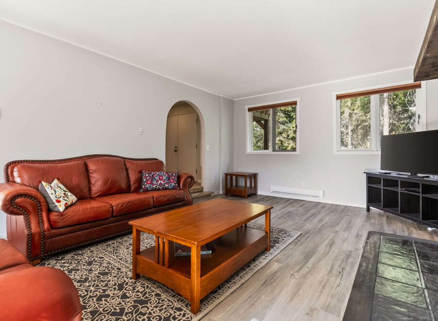 Step into this inviting living room featuring a plush, tufted leather sofa perfect for relaxation.