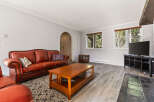 Step into this inviting living room featuring a plush, tufted leather sofa perfect for relaxation.
