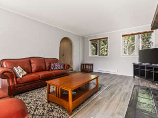 Step into this inviting living room featuring a plush, tufted leather sofa perfect for relaxation.