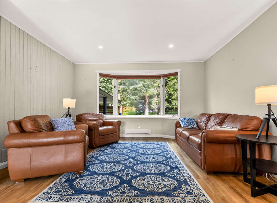 Step into this inviting living room, featuring plush brown leather sofas and armchairs perfect for relaxation.