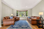 Step into this inviting living room, featuring plush brown leather sofas and armchairs perfect for relaxation.