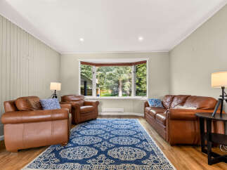 Step into this inviting living room, featuring plush brown leather sofas and armchairs perfect for relaxation.