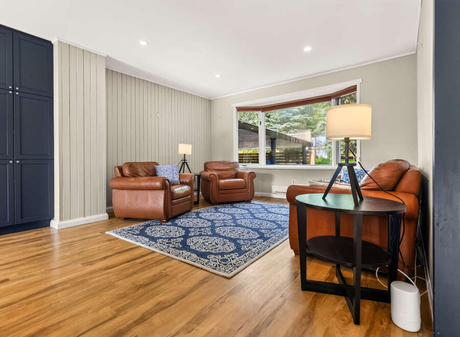 Step into this inviting living room featuring rich leather armchairs and a striking blue patterned rug, perfect for cozy gatherings.