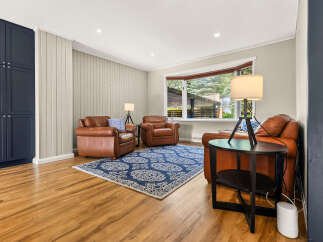 Step into this inviting living room featuring rich leather armchairs and a striking blue patterned rug, perfect for cozy gatherings.
