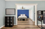 Discover a serene bedroom featuring a comfortable bed with storage drawers, complemented by a vibrant blue accent wall.