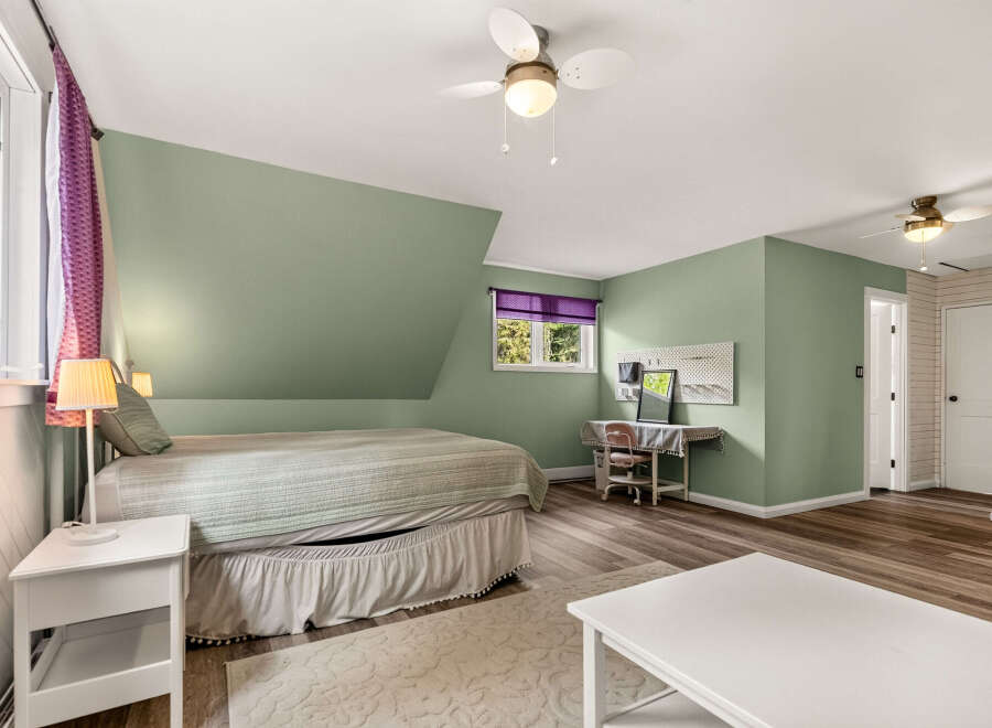 Discover this charming bedroom featuring a comfortable bed with a textured quilt and a decorative bed skirt.