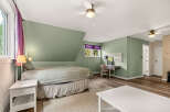 Discover this charming bedroom featuring a comfortable bed with a textured quilt and a decorative bed skirt.