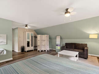 Discover this spacious studio apartment featuring a comfortable living area with a plush sofa and a coffee table, perfect for relaxation.