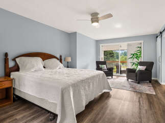 Experience comfort and style in this inviting bedroom, featuring a plush king-sized bed adorned with a textured white quilt.
