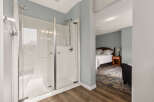 Experience modern comfort with this spacious walk-in shower, featuring sleek glass doors and a rainfall showerhead.