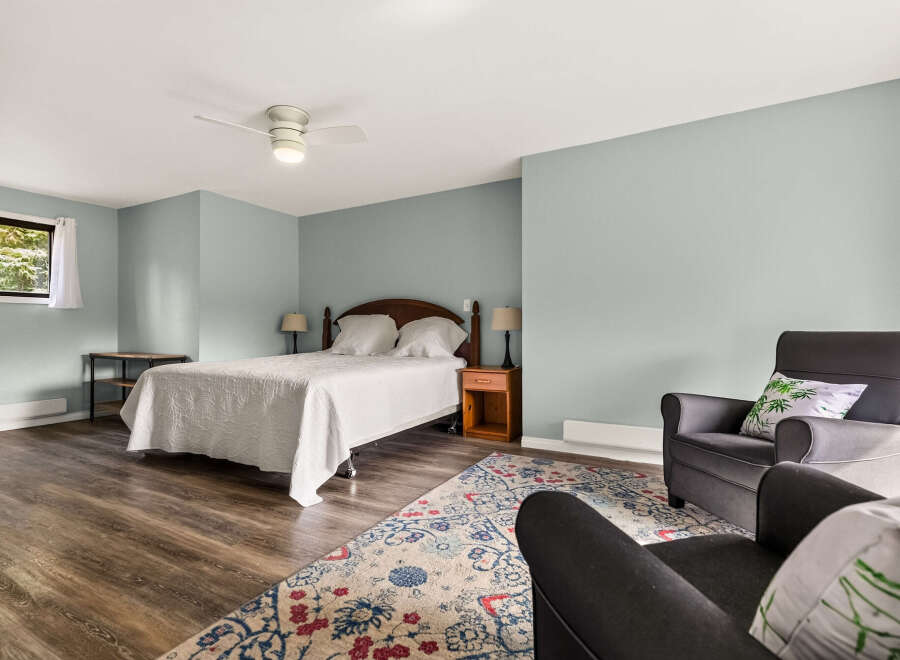 Discover comfort and style in this inviting bedroom, featuring a plush queen-size bed adorned with a crisp white quilted coverlet.