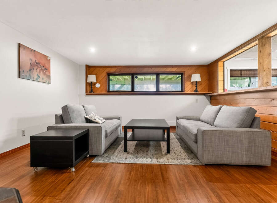 This inviting living room features a cozy seating area with two plush grey sofas and a modern black coffee table, perfect for relaxation.