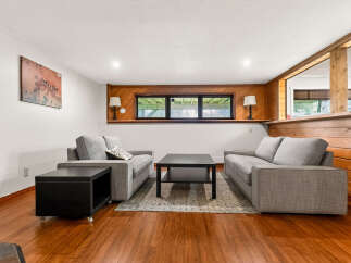 This inviting living room features a cozy seating area with two plush grey sofas and a modern black coffee table, perfect for relaxation.