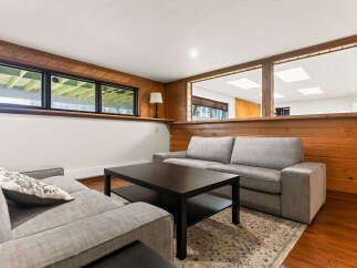 This inviting living space features a cozy sectional sofa and a dark wood coffee table, perfect for relaxing evenings.