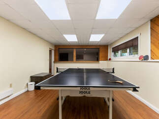 Enjoy endless fun in this recreational room featuring a professional JOOLA ping pong table.