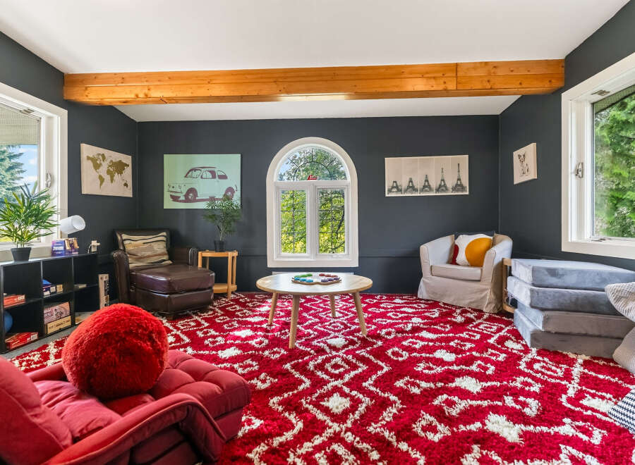 This inviting living room features a bold red and white patterned rug that adds a vibrant touch to the space.