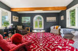 This inviting living room features a bold red and white patterned rug that adds a vibrant touch to the space.