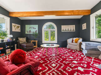 This inviting living room features a bold red and white patterned rug that adds a vibrant touch to the space.