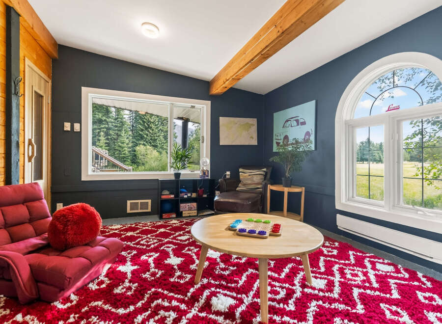Step into this cozy living room featuring a vibrant red shag rug and a plush red armchair, perfect for relaxation.
