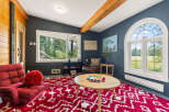 Step into this cozy living room featuring a vibrant red shag rug and a plush red armchair, perfect for relaxation.