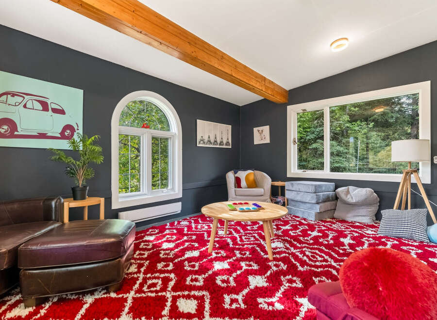This cozy living room features a large red and white patterned rug, perfect for family gatherings or playtime.