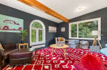 This cozy living room features a large red and white patterned rug, perfect for family gatherings or playtime.