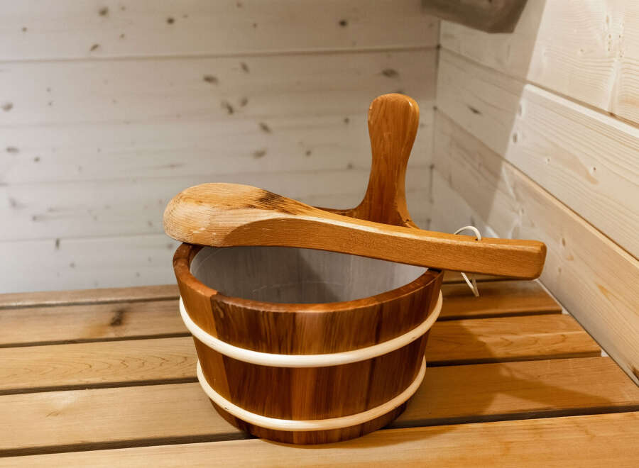 Experience ultimate relaxation in this traditional sauna, complete with a wooden bucket and ladle for a perfect steam.