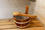 Experience ultimate relaxation in this traditional sauna, complete with a wooden bucket and ladle for a perfect steam.