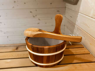 Experience ultimate relaxation in this traditional sauna, complete with a wooden bucket and ladle for a perfect steam.