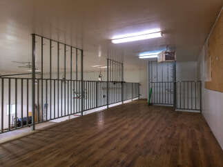 Explore this versatile loft space featuring a durable wood-look floor and sturdy metal railings, perfect for various uses.