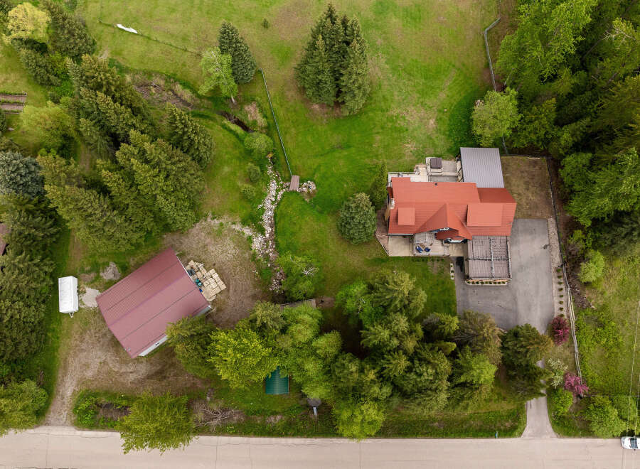 Discover this stunning property featuring a spacious main house with a red tile roof and a large deck, perfect for outdoor entertaining.