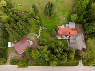 Discover this stunning property featuring a spacious main house with a red tile roof and a large deck, perfect for outdoor entertaining.