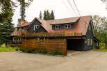Discover this stunning dark-sided home featuring a durable, reddish-brown tiled roof and a modern wooden fence.