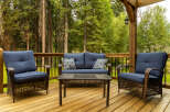 Enjoy the serene outdoors from this charming deck, featuring comfortable seating and a stylish coffee table.