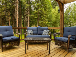 Enjoy the serene outdoors from this charming deck, featuring comfortable seating and a stylish coffee table.