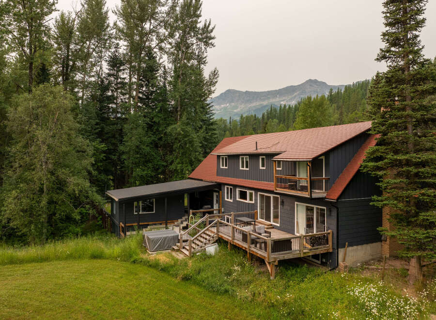 Nestled amidst lush greenery and towering trees, this charming home offers a serene mountain retreat.