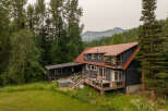 Nestled amidst lush greenery and towering trees, this charming home offers a serene mountain retreat.