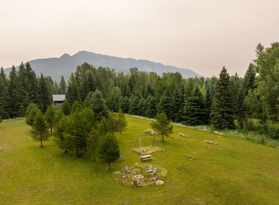 Escape to this serene mountain retreat featuring a charming cabin nestled amongst towering evergreen trees.
